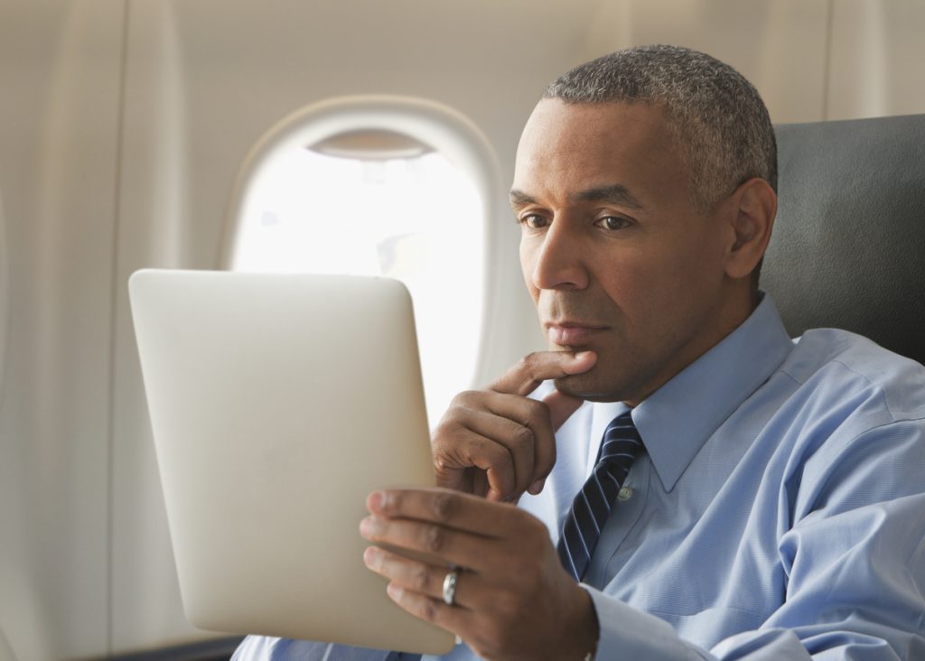Man On Tablet In-Flight wifi | AdonisOne
