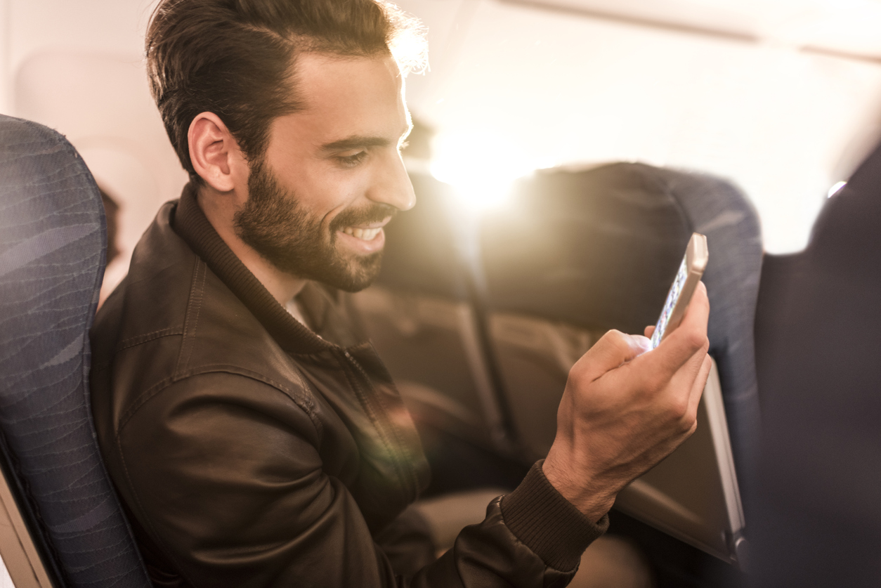 Happy Airplane Passenger using an in-flight entertainment systems | AdonisOne