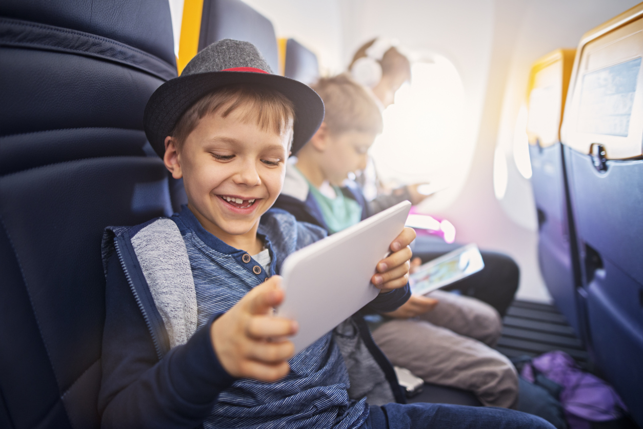 Children using the AdonisOne portable in-flight entertainment systems on an aircraft